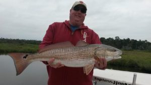 Daytona Beach Fishing Report, capt billy pettigrew holding redfish